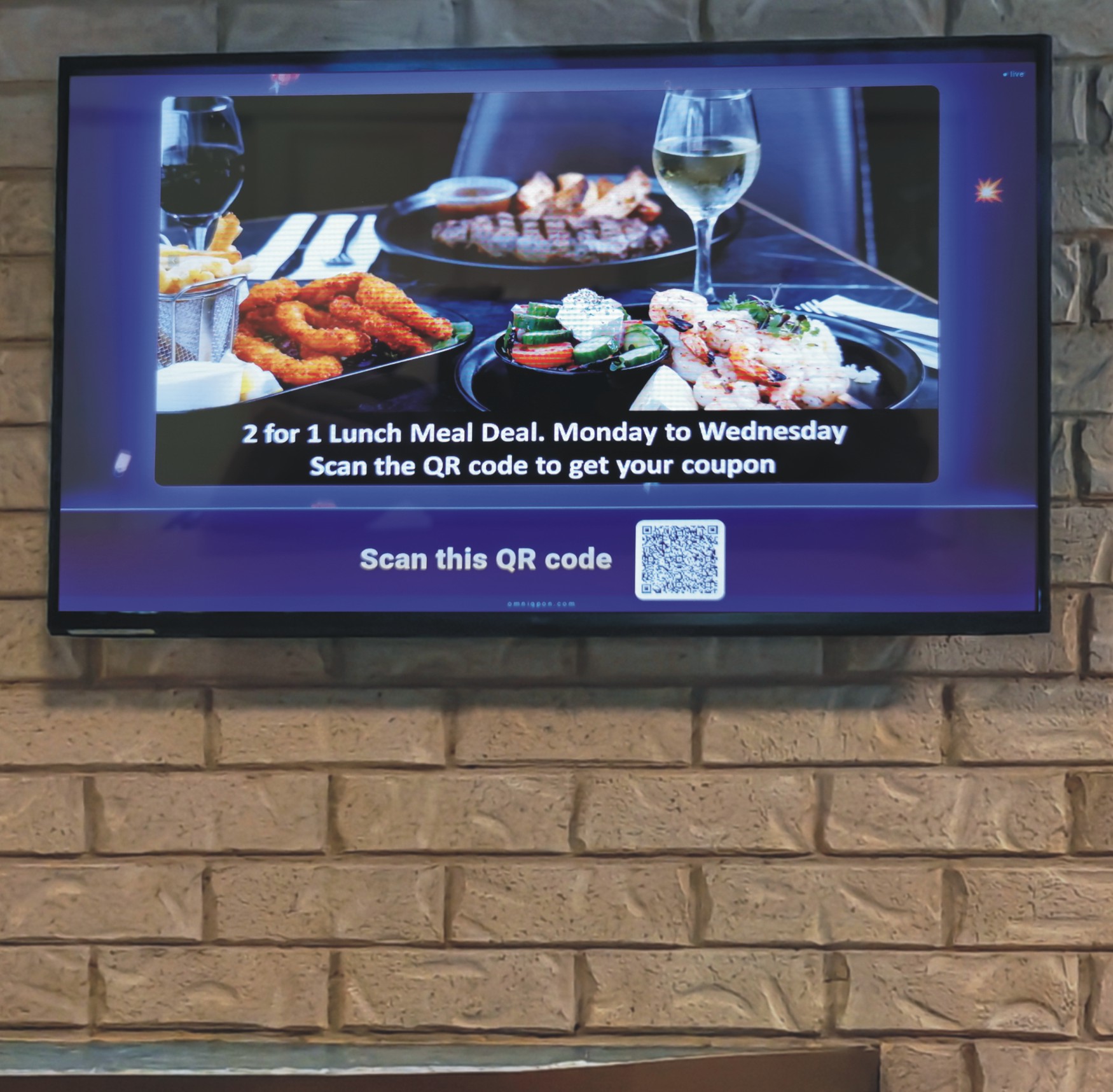 In-venue screen showing a 2-for-1 lunch meal deal with a scannable QR code